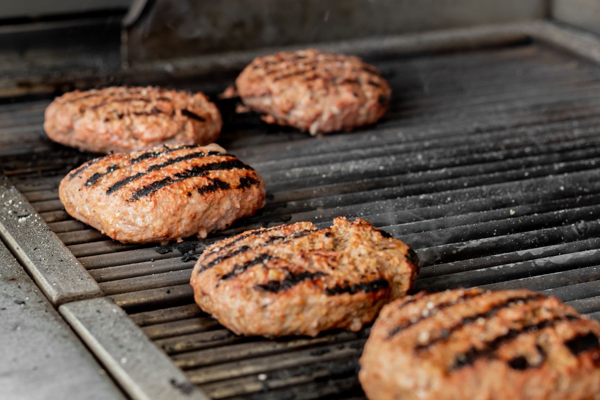 Burger patties with sear marks on a heavy grill grate