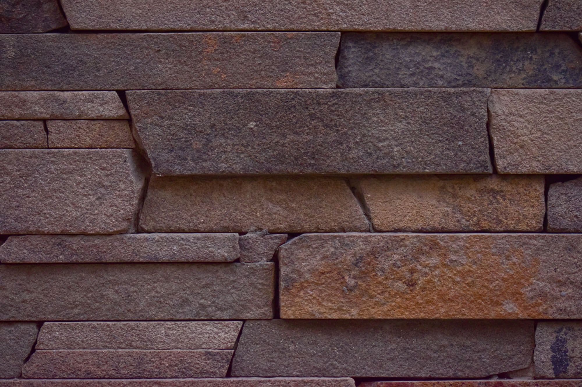 Close-up of a stacked natural stone wall in brown and grey tones